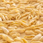 A close-up view of uncooked cavatelli pasta, showcasing it's texture and freshness.