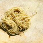 a pile of spaghetti sitting on top of a wooden table